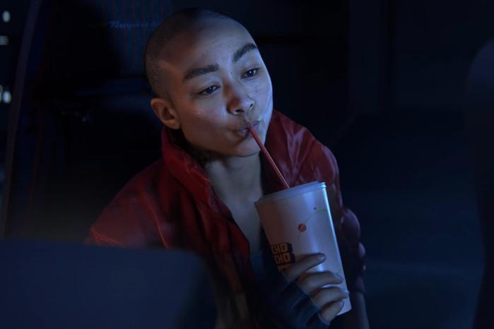 Intergalactic-The-Heretic-Prophet-release-date Close up of Jordan A Mun from Intergalactic: The Heretic Prophet. She's drinking from a takeaway paper cup through a straw.